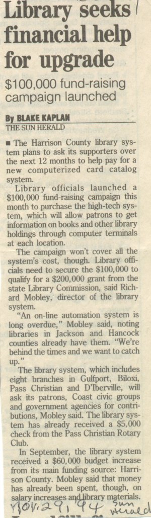 A newspaper clipping titled “Library seeks financial help for upgrade” with a subheading “$100,000 fund-raising campaign launched.” The article discusses the Harrison County Library System’s plan to raise funds for a computerized card catalog system, mentions a $200,000 grant requirement, and includes statements from library officials about automation and contributions from civic groups.