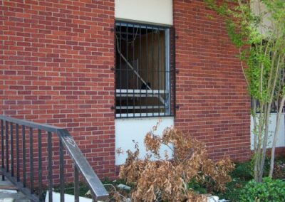 A gutted library interior with exposed wall studs and large piles of broken flooring, carpet, insulation, and drywall scattered across the room. A cleanup vehicle is parked inside near the far wall.