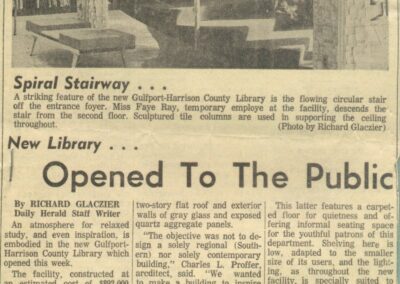 A newspaper clipping featuring a large photo of a woman standing on a spiral staircase inside a library, followed by an article titled “New Library… Opened To The Public,” describing the opening of the Gulfport–Harrison County Library.