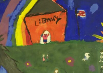 A close‑up of a brightly painted mural shows a red building labeled “Library,” a rainbow arching overhead, small figures on a green lawn, and an American flag waving against a deep blue sky.